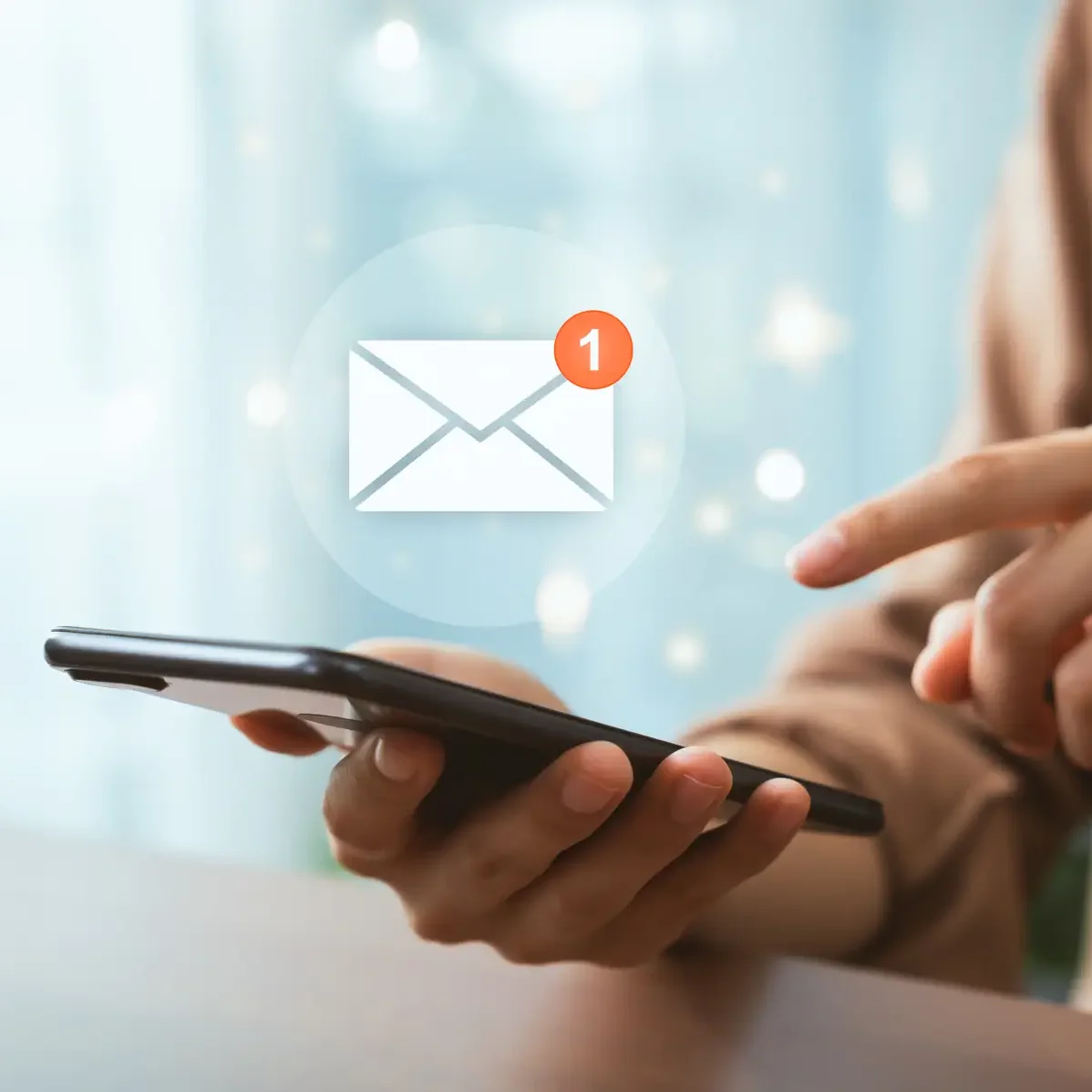 Eine Hand hält ein Smartphone und zeigt einen digitalen Bildschirm mit Benachrichtigungen über neue E-Mails.
